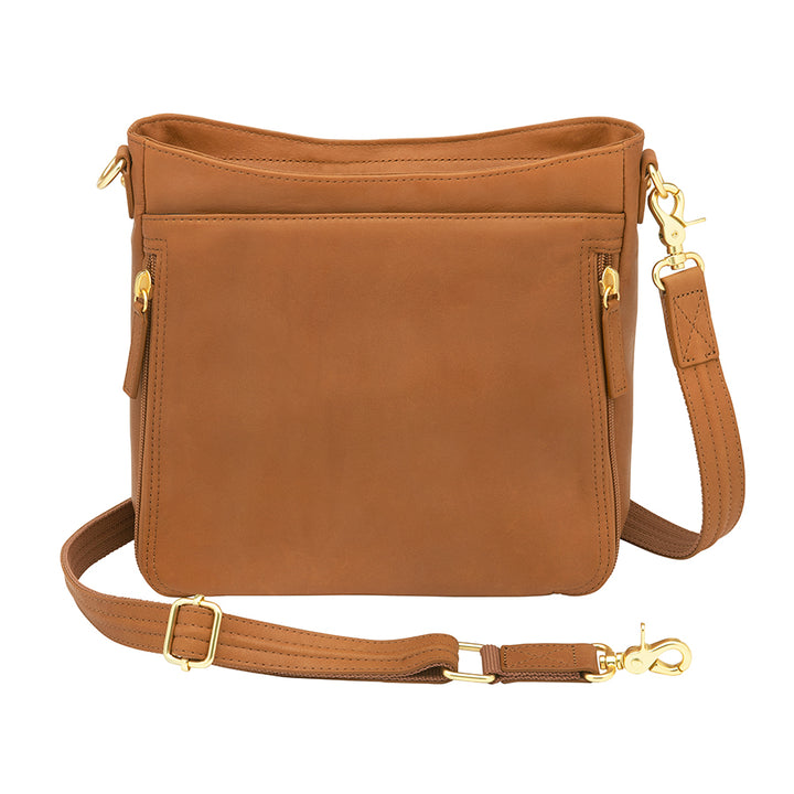Slim tan concealed carry crossbody bag made from brushed USA cowhide, featuring RFID-blocking front organizer, slash-resistant adjustable strap, and fast-access top-draw gun compartment for left or right-hand draw.