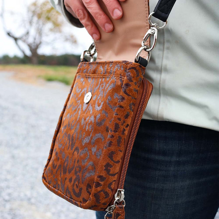 Minimalist black or cheetah-print concealed carry crossbody phone pouch with slash-resistant strap, magnetic flap, and padded compartment for discreet firearm storage. Lightweight and compact, fits essentials like phone, wallet, and micro pistols such as Kahr 380 or Ruger LCP.