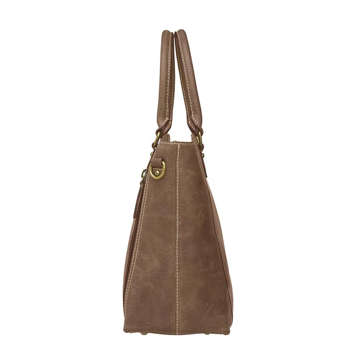 Distressed brown full grain buffalo leather town tote with concealed carry compartment. Vintage-inspired patina develops with use. Features reinforced slash-resistant shoulder strap, padded interior for gun protection, and dual top handles for versatile carry. Designed for ambidextrous draw, includes multiple pockets for phone, pepper spray, and essentials. Tested with popular pistols, equipped with Mernickle holster. Durable and stylish everyday concealed carry purse.