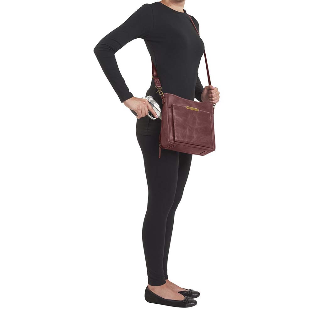 Red distressed leather concealed carry crossbody purse with RFID-secured card slots, top-draw access for right or left hand, fits compact pistols like Glock 26 or HK VP9, slash-resistant adjustable strap.