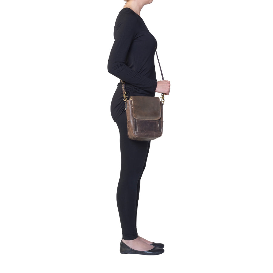 Side profile of GTM/CZY-80 Distressed Leather Crossbody Satchel worn by model showing adjustable slash-resistant shoulder strap and slim profile for comfortable concealed carry