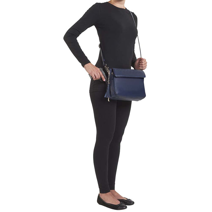 Indigo blue clutch-style concealed carry purse in soft American cowhide with RFID-protected front organizer, adjustable crossbody slash-resistant strap, triple-zip gun access for Glock 27, Ruger LCP, S&W Shield, and more. Lightweight, padded, stylish, and discreet everyday carry solution for women.