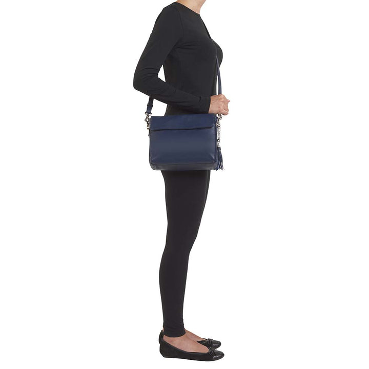 Indigo blue clutch-style concealed carry purse in soft American cowhide with RFID-protected front organizer, adjustable crossbody slash-resistant strap, triple-zip gun access for Glock 27, Ruger LCP, S&W Shield, and more. Lightweight, padded, stylish, and discreet everyday carry solution for women.