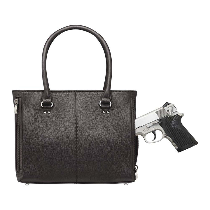 gun going into a black leather imeless Traditional Elegance Concealed Carry Purse with pebble-textured cowhide leather. Features 11-ply steel cable reinforced, slash-resistant carry handles, designed for left or right-handed use. Spacious interior with center zippered divider, leather-trimmed pockets, and zippered pocket. Magnetic snaps close the open top. Includes metal feet for bottom protection. Khaki GTM logo lining for easy visibility. Includes holster compatibility.