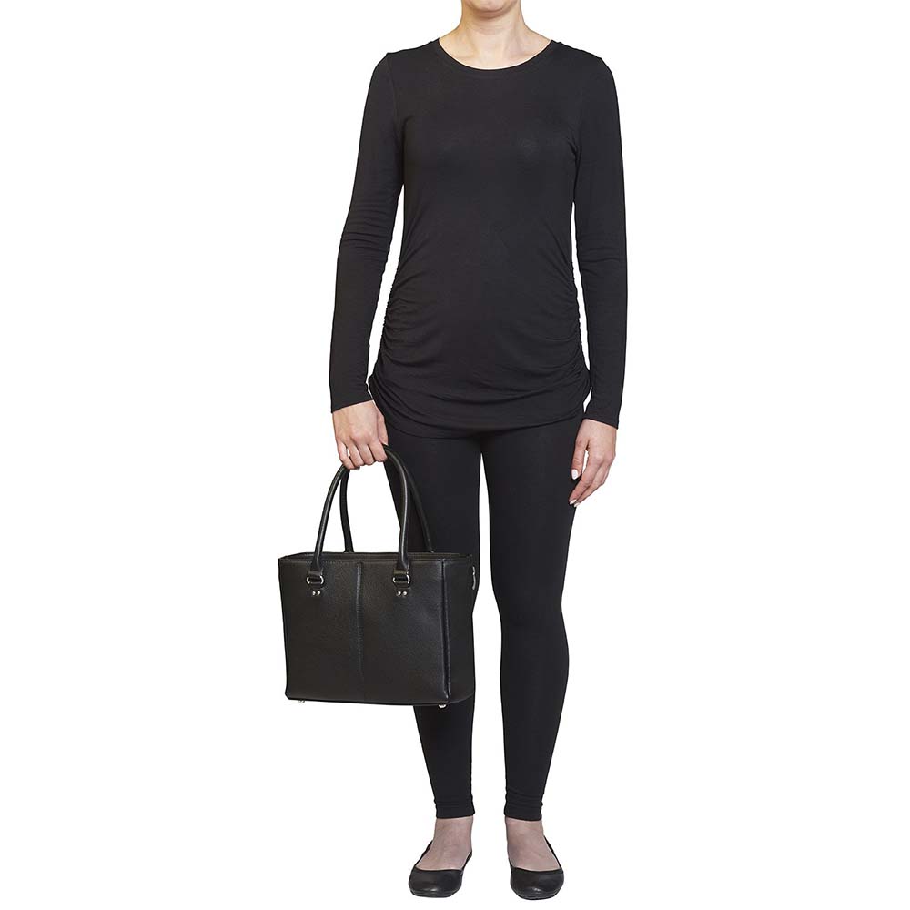 model holding a black timeless Traditional Elegance Concealed Carry Purse with pebble-textured cowhide leather. Features 11-ply steel cable reinforced, slash-resistant carry handles, designed for left or right-handed use. Spacious interior with center zippered divider, leather-trimmed pockets, and zippered pocket. Magnetic snaps close the open top. Includes metal feet for bottom protection. Khaki GTM logo lining for easy visibility. Includes holster compatibility.