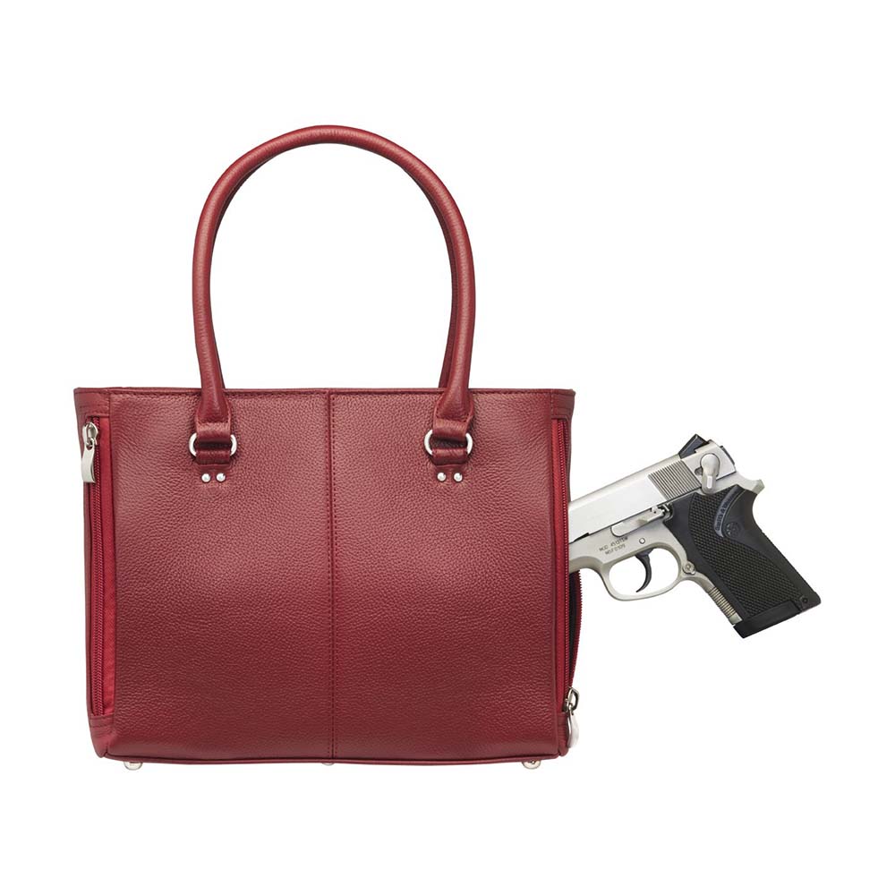 gun going into the red timeless Traditional Elegance Concealed Carry Purse with pebble-textured cowhide leather. Features 11-ply steel cable reinforced, slash-resistant carry handles, designed for left or right-handed use. Spacious interior with center zippered divider, leather-trimmed pockets, and zippered pocket. Magnetic snaps close the open top. Includes metal feet for bottom protection. Khaki GTM logo lining for easy visibility. Includes holster compatibility.