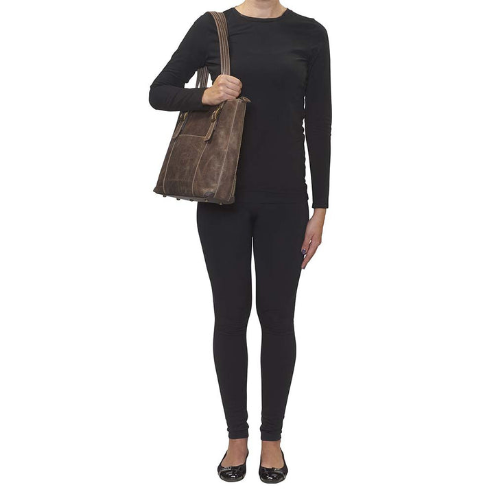 woman carrying Distressed vintage buffalo leather shoulder portfolio concealed carry purse with slash-resistant double shoulder straps, patent-pending CCW rear zippered compartment for left or right-hand draw, padded to prevent imprinting, includes Mernickle holster, fits iPads and small laptops, RFID-protected organizer, top zipper closure, and chrome feet for stability—ideal for office or everyday carry.