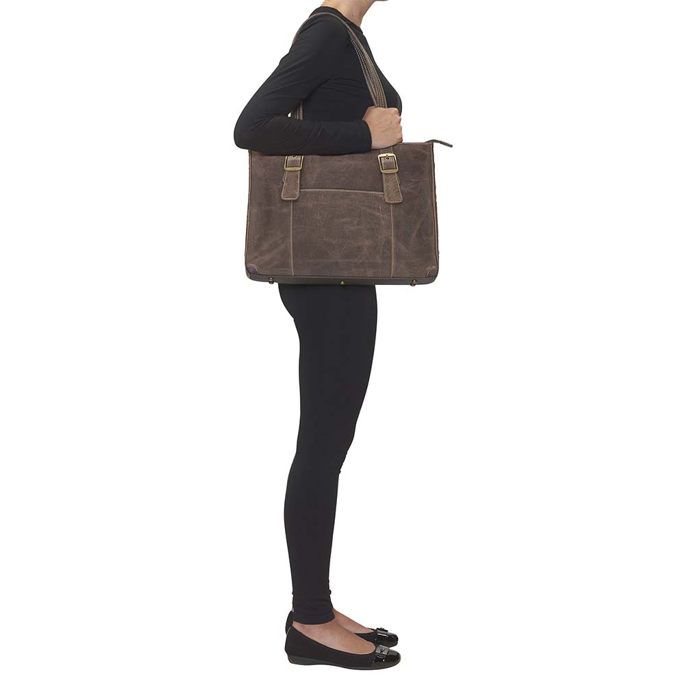 woman carrying from the side a Distressed vintage buffalo leather shoulder portfolio concealed carry purse with slash-resistant double shoulder straps, patent-pending CCW rear zippered compartment for left or right-hand draw, padded to prevent imprinting, includes Mernickle holster, fits iPads and small laptops, RFID-protected organizer, top zipper closure, and chrome feet for stability—ideal for office or everyday carry.
