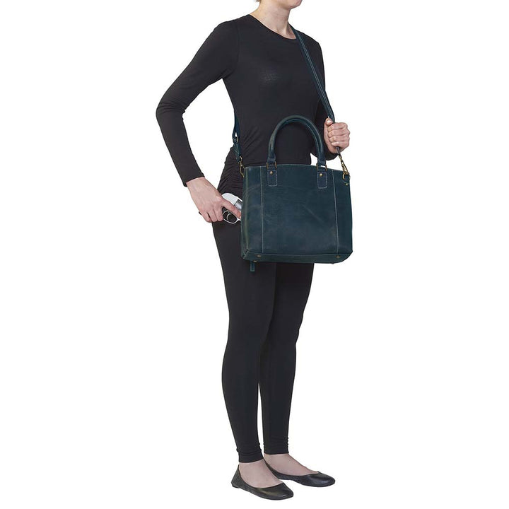 Sophisticated gray distressed full grain buffalo leather concealed carry town tote. Features vintage patina finish that ages gracefully, lightweight yet durable. Equipped with slash-resistant shoulder strap and padded interior for imprint protection. Designed for both left and right handed users, with ample storage including exterior and interior zip pockets. Comes with Mernickle standard holster, tested for reliable concealed carry performance.