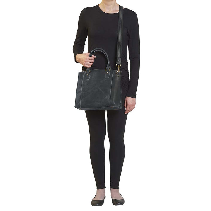 Sophisticated gray distressed full grain buffalo leather concealed carry town tote. Features vintage patina finish that ages gracefully, lightweight yet durable. Equipped with slash-resistant shoulder strap and padded interior for imprint protection. Designed for both left and right handed users, with ample storage including exterior and interior zip pockets. Comes with Mernickle standard holster, tested for reliable concealed carry performance.