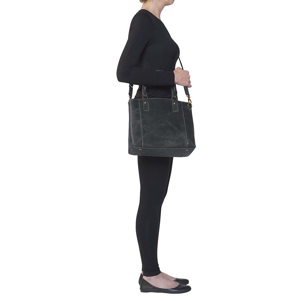 Sophisticated gray distressed full grain buffalo leather concealed carry town tote. Features vintage patina finish that ages gracefully, lightweight yet durable. Equipped with slash-resistant shoulder strap and padded interior for imprint protection. Designed for both left and right handed users, with ample storage including exterior and interior zip pockets. Comes with Mernickle standard holster, tested for reliable concealed carry performance.