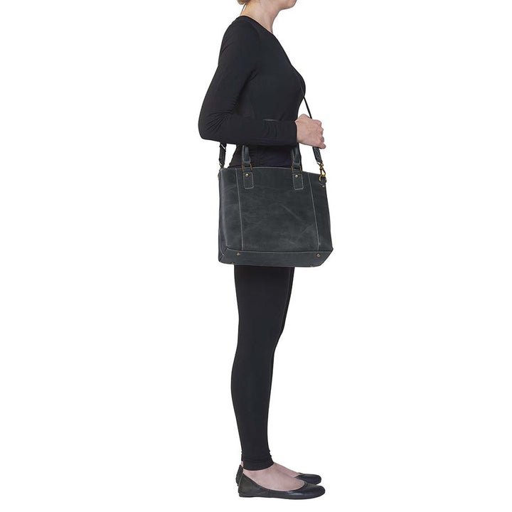Sophisticated gray distressed full grain buffalo leather concealed carry town tote. Features vintage patina finish that ages gracefully, lightweight yet durable. Equipped with slash-resistant shoulder strap and padded interior for imprint protection. Designed for both left and right handed users, with ample storage including exterior and interior zip pockets. Comes with Mernickle standard holster, tested for reliable concealed carry performance.