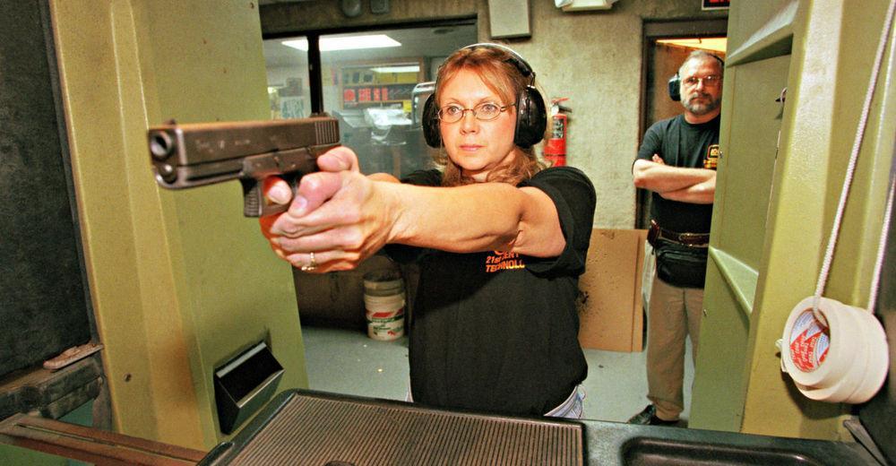 Women holding a pistol at a gun range