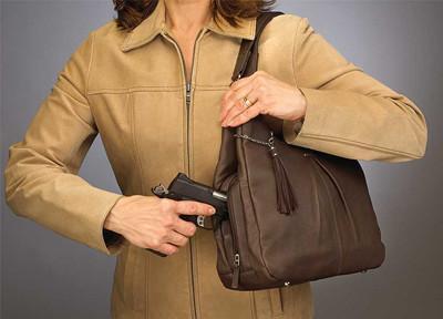 woman holding a purse with a gun