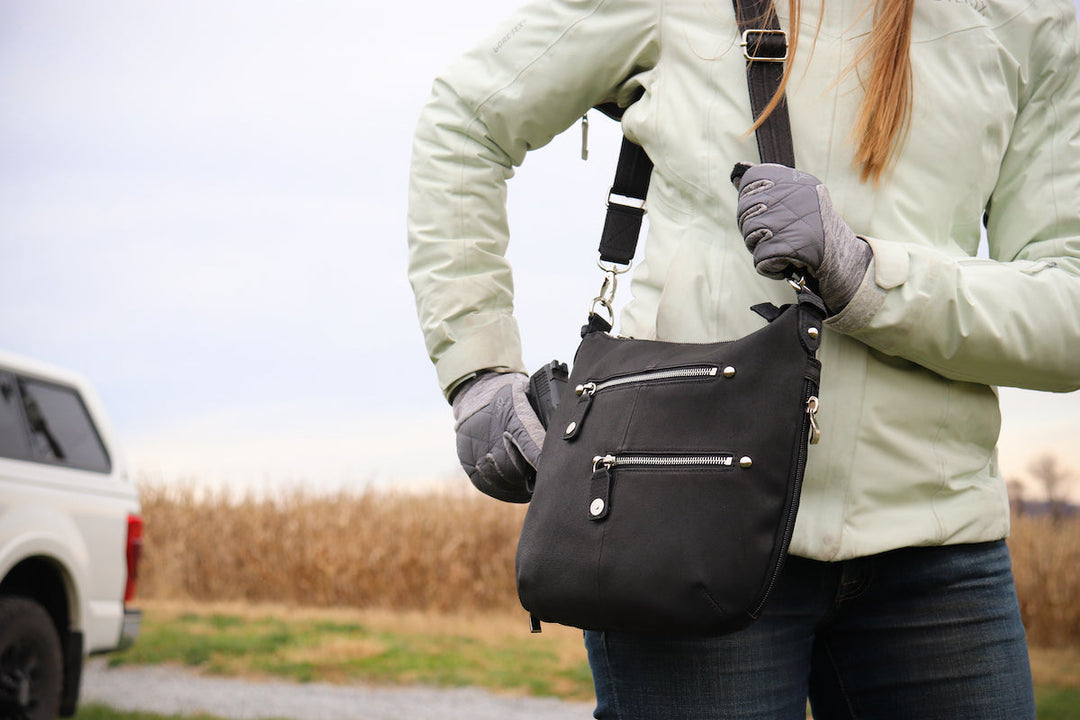 GTM women's Off-Body Carry purse in front of a truck and corn field