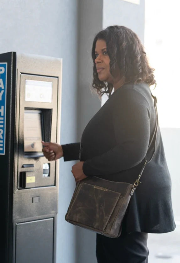 lady at a bank pulling out cash and with a leather purse
