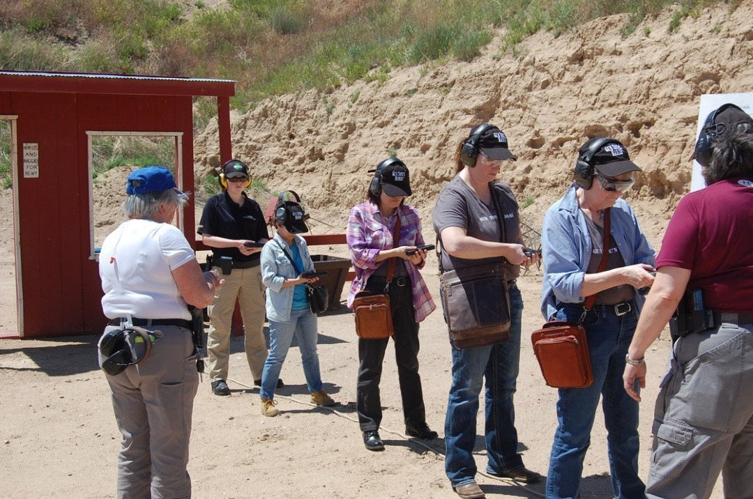 women at a gun range training