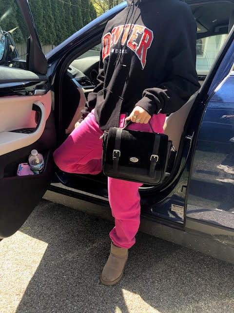 young woman getting out of a car with a school girl purse