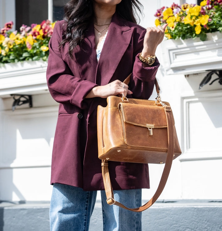 GTMoriginals Avenue large sling satchel concealed carry bag GTM-32/CRML held in hand in front of a building.