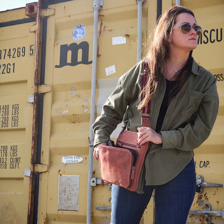 model with Vintage distressed buffalo leather concealed carry crossbody purse with adjustable slash-resistant strap, left and right-handed access, and a secure gun compartment designed for fast draw. Includes holster and fits compact handguns like S&W Shield, Ruger LCP, and Glock 42.