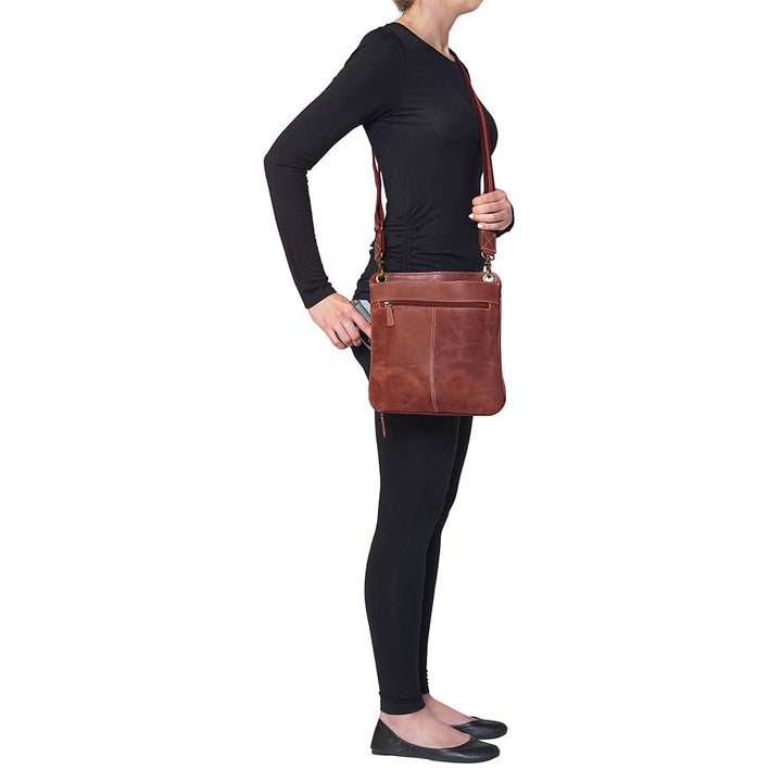 Vintage distressed buffalo leather concealed carry crossbody purse with adjustable slash-resistant strap, left and right-handed access, and a secure gun compartment designed for fast draw. Includes holster and fits compact handguns like S&W Shield, Ruger LCP, and Glock 42.