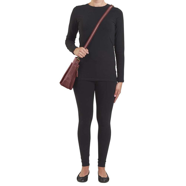 Red distressed leather concealed carry crossbody purse with RFID-secured card slots, top-draw access for right or left hand, fits compact pistols like Glock 26 or HK VP9, slash-resistant adjustable strap.