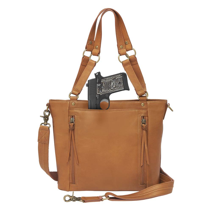 Tan concealed carry BOHO tote purse with top-access CCW compartment, symbolic butterfly and flower debossed leather, slash-proof straps, RFID-blocking zip pocket, and room for compact pistols like CZ P10, M&P Shield, and S&W EZ—each bag uniquely aged from natural tanning.