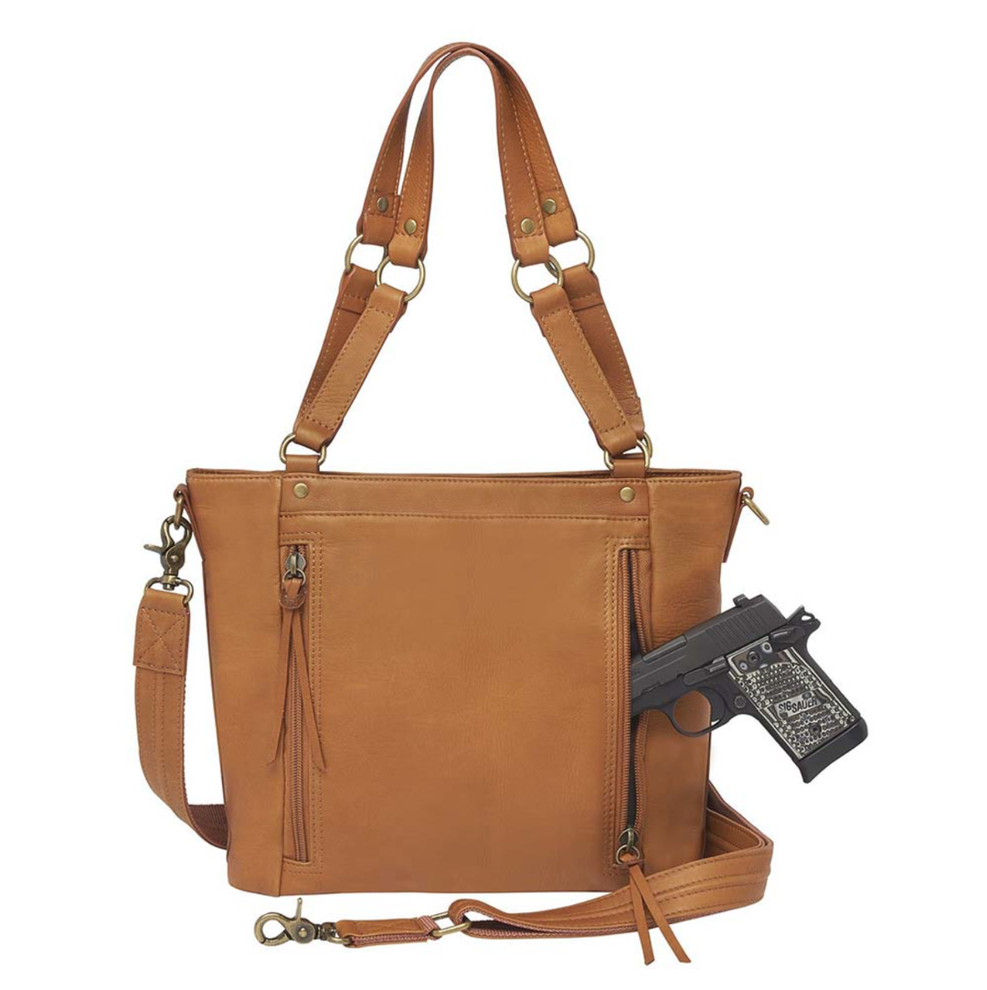 Tan concealed carry BOHO tote purse with top-access CCW compartment, symbolic butterfly and flower debossed leather, slash-proof straps, RFID-blocking zip pocket, and room for compact pistols like CZ P10, M&P Shield, and S&W EZ—each bag uniquely aged from natural tanning.
