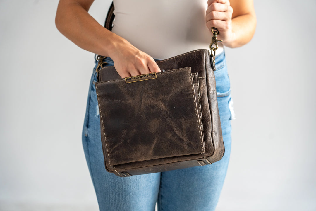 Gun Tote'N Mamas Slim Crossbody Concealed Carry Purse in distressed buffalo leather, shown with model wearing the shoulder bag.