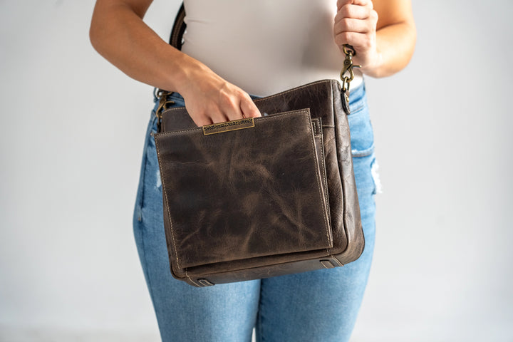 Gun Tote'N Mamas Slim Crossbody Concealed Carry Purse in distressed buffalo leather, shown with model wearing the shoulder bag.