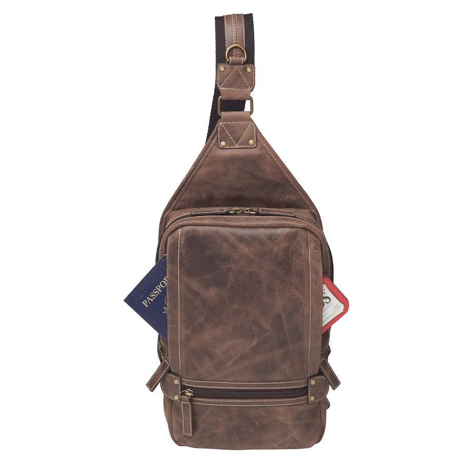 Distressed brown buffalo leather sling concealed carry backpack with tactical organization, RFID zip pocket, padded holster compartment for Glock 19, Sig P320, and HK VP9, slash-proof strap, and swing-front crossbody design with 3 exterior zip pockets and morale patch zone